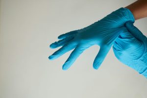 Person taking on cleaning gloves
